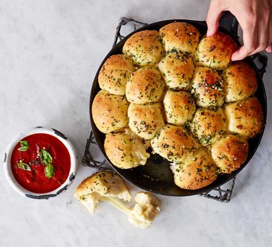 Cheese-stuffed garlic dough balls with a tomato sauce dip