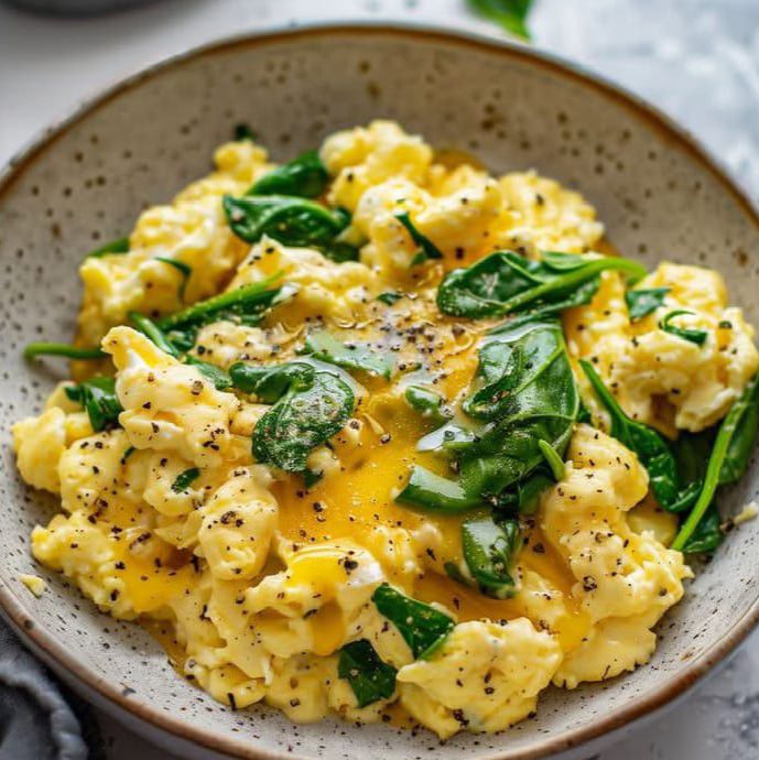 Scrambled eggs with cheese and sauteed spinach